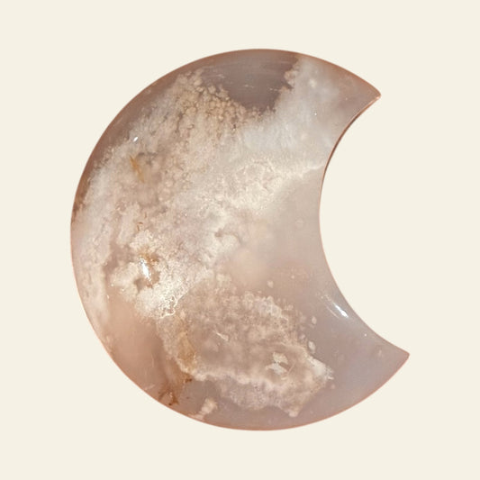 Half-moon shaped stone with a textured surface on a beige background