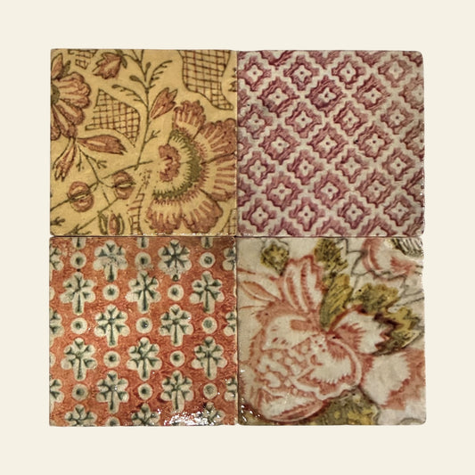 Four square marble coasters with different patterns arranged in a grid on a light  background