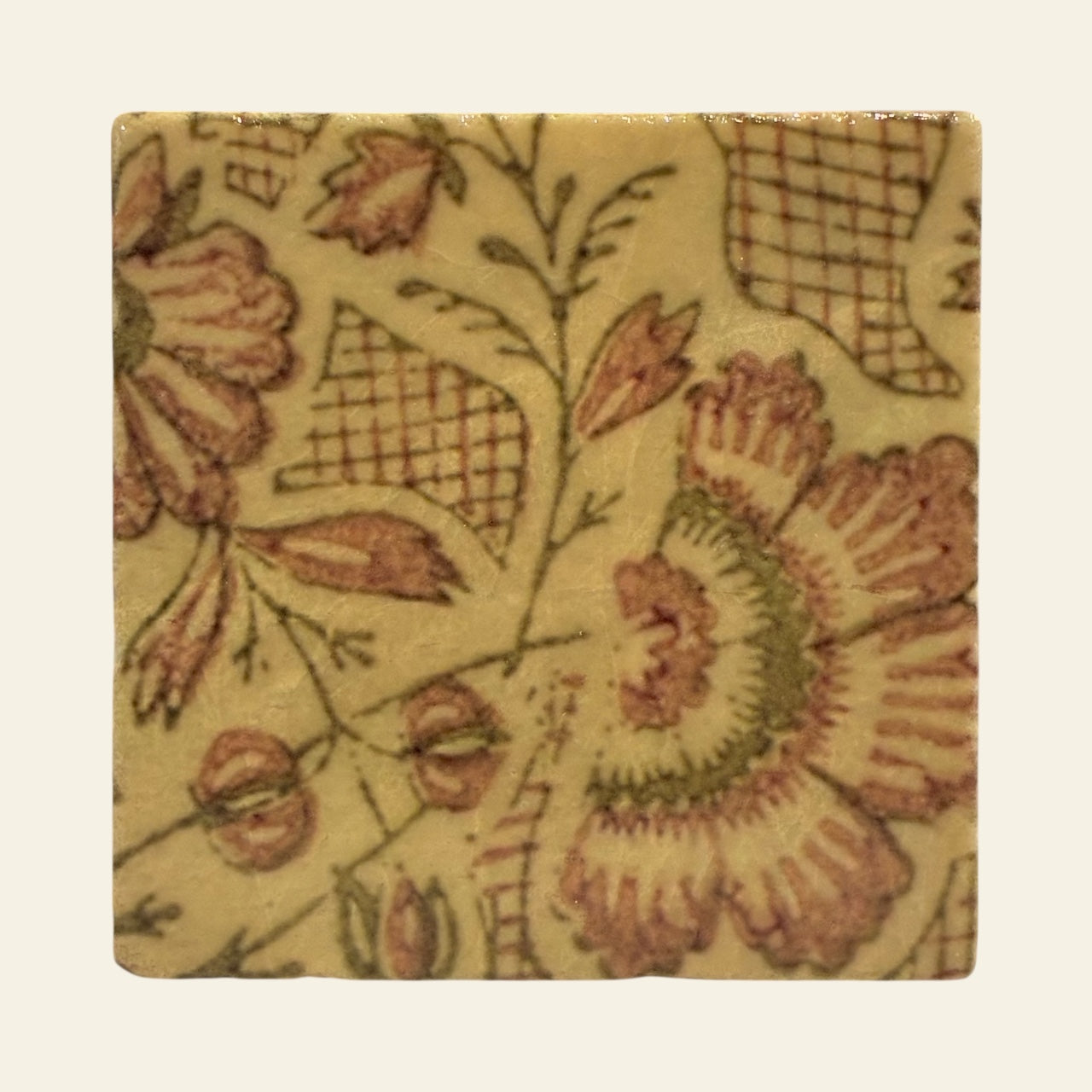 Square tile with floral pattern on a beige background