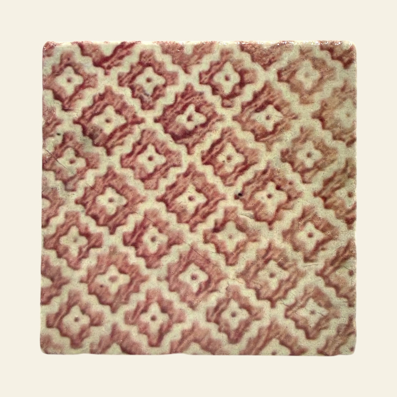 Patterned stone coaster with a diamond design on a beige background