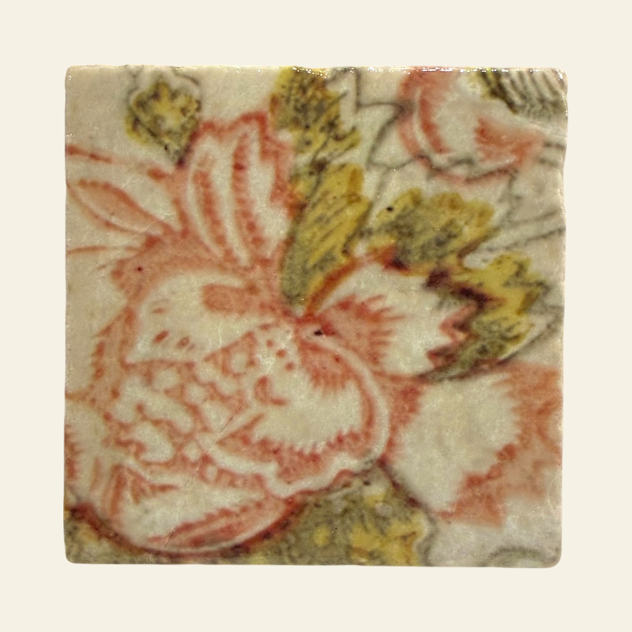 Square tile with blush and green floral pattern on a beige background