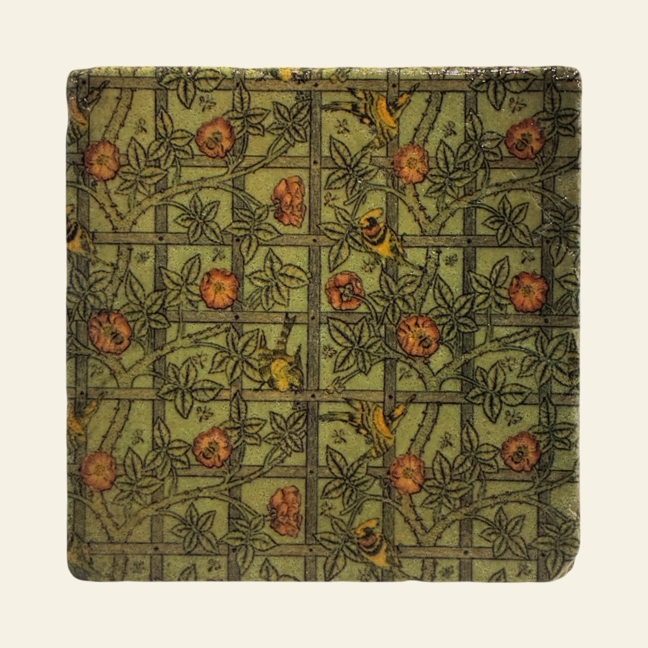 Green vines and floral stone coaster against a beige background
