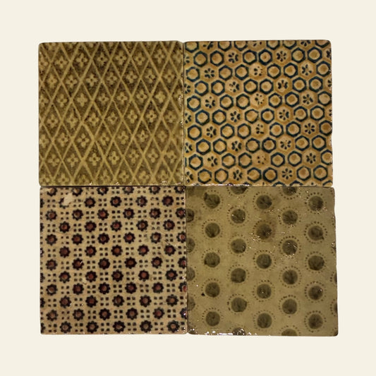 Four different textured patterned coasters on a beige background