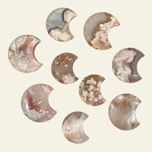 Set of semi-precious stone crescent moon shapes on a beige background