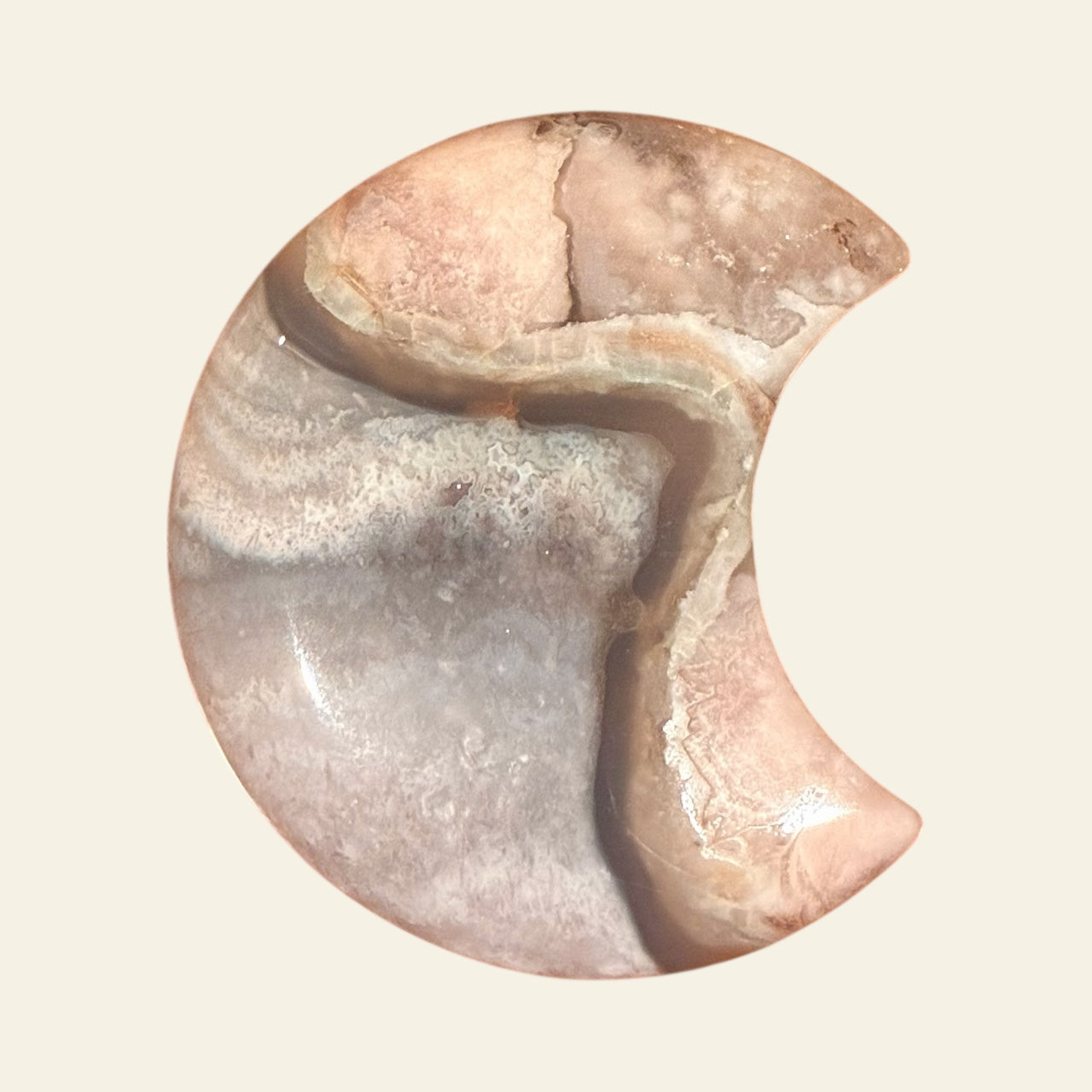 Half moon stone with natural patterns on a beige background