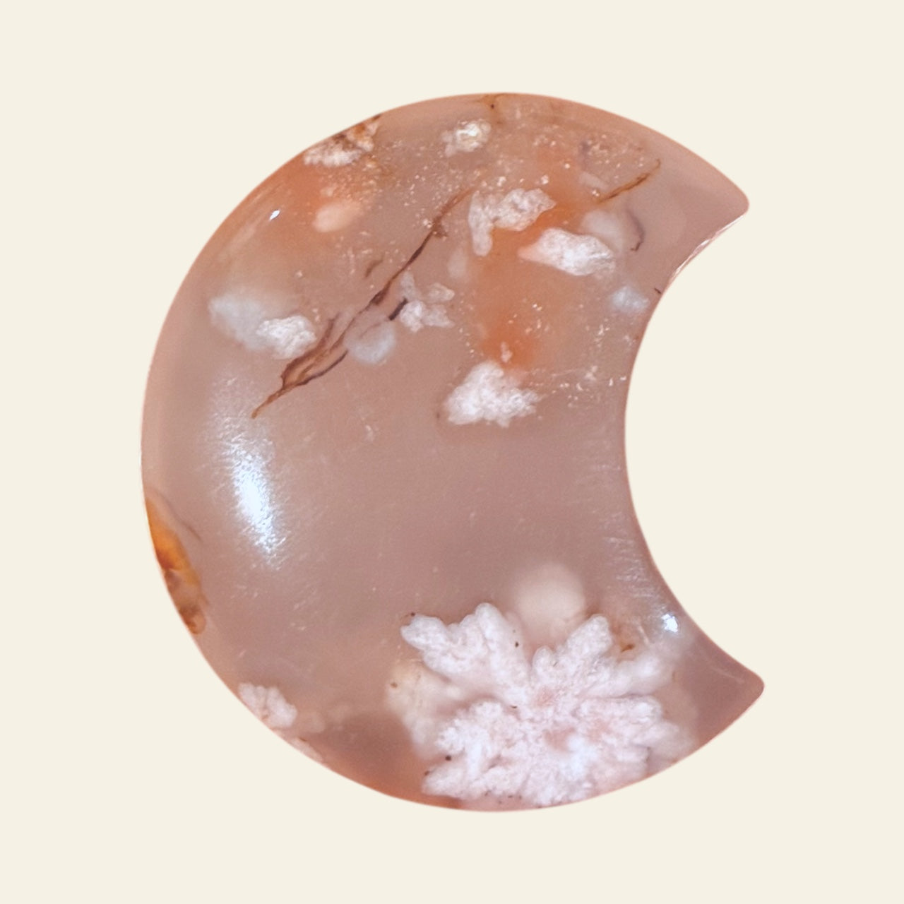 Half moon-shaped stone with a textured surface on a beige background