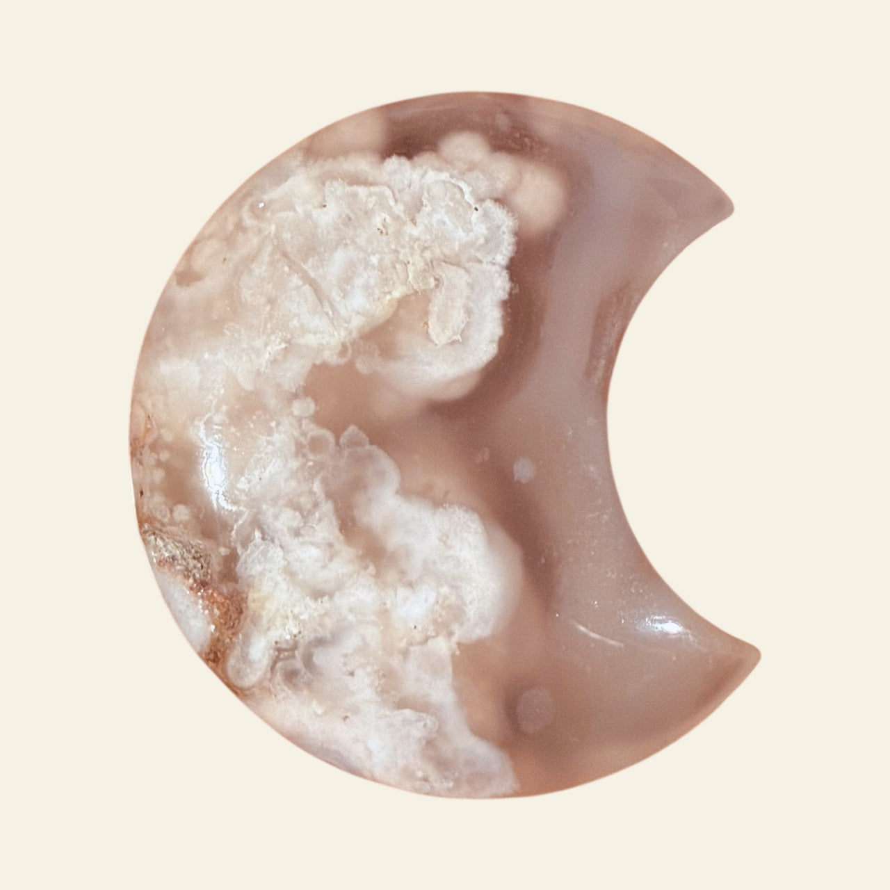 Half moon-shaped stone with a textured surface on a beige background