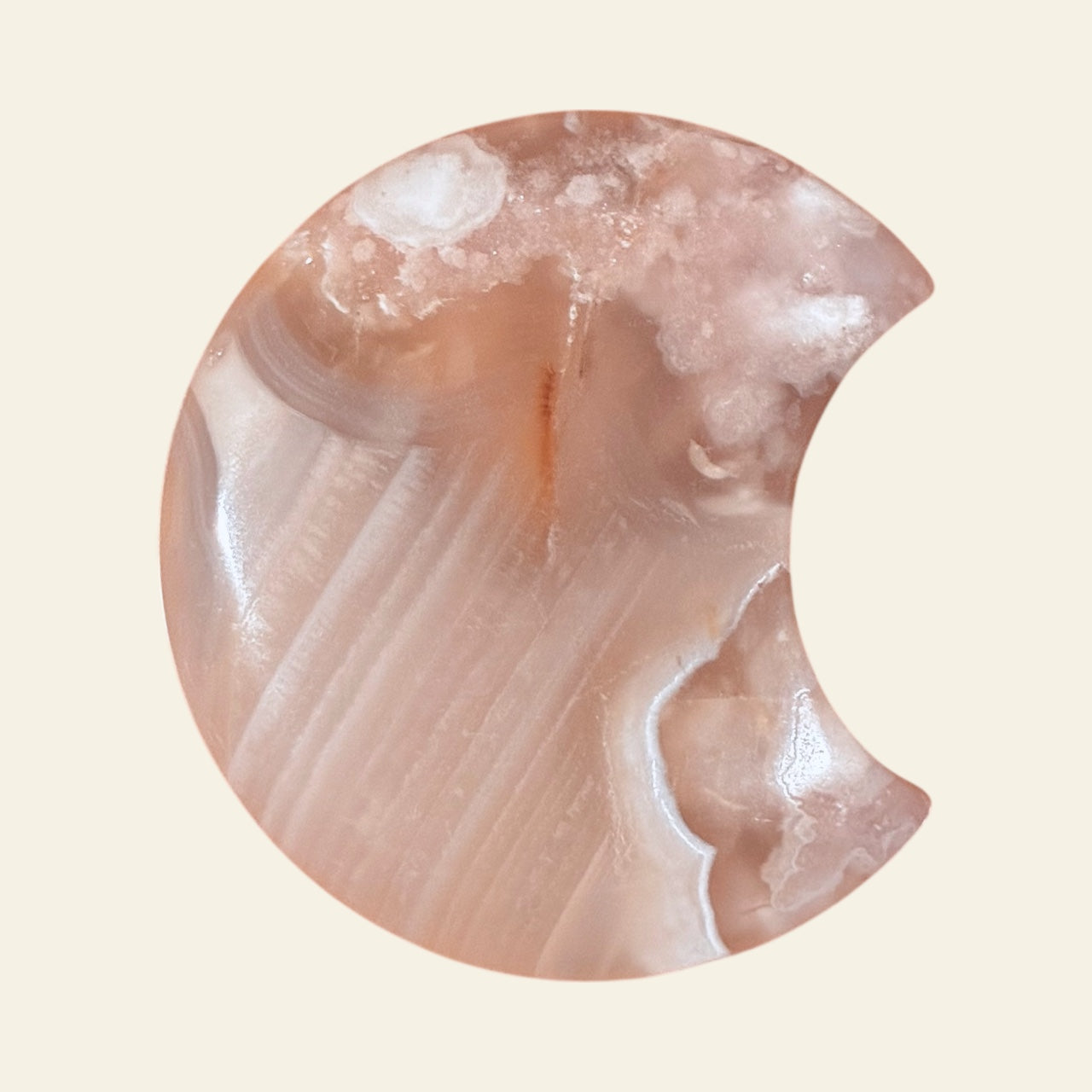 Close-up of a polished stone with concentric patterns on a beige background