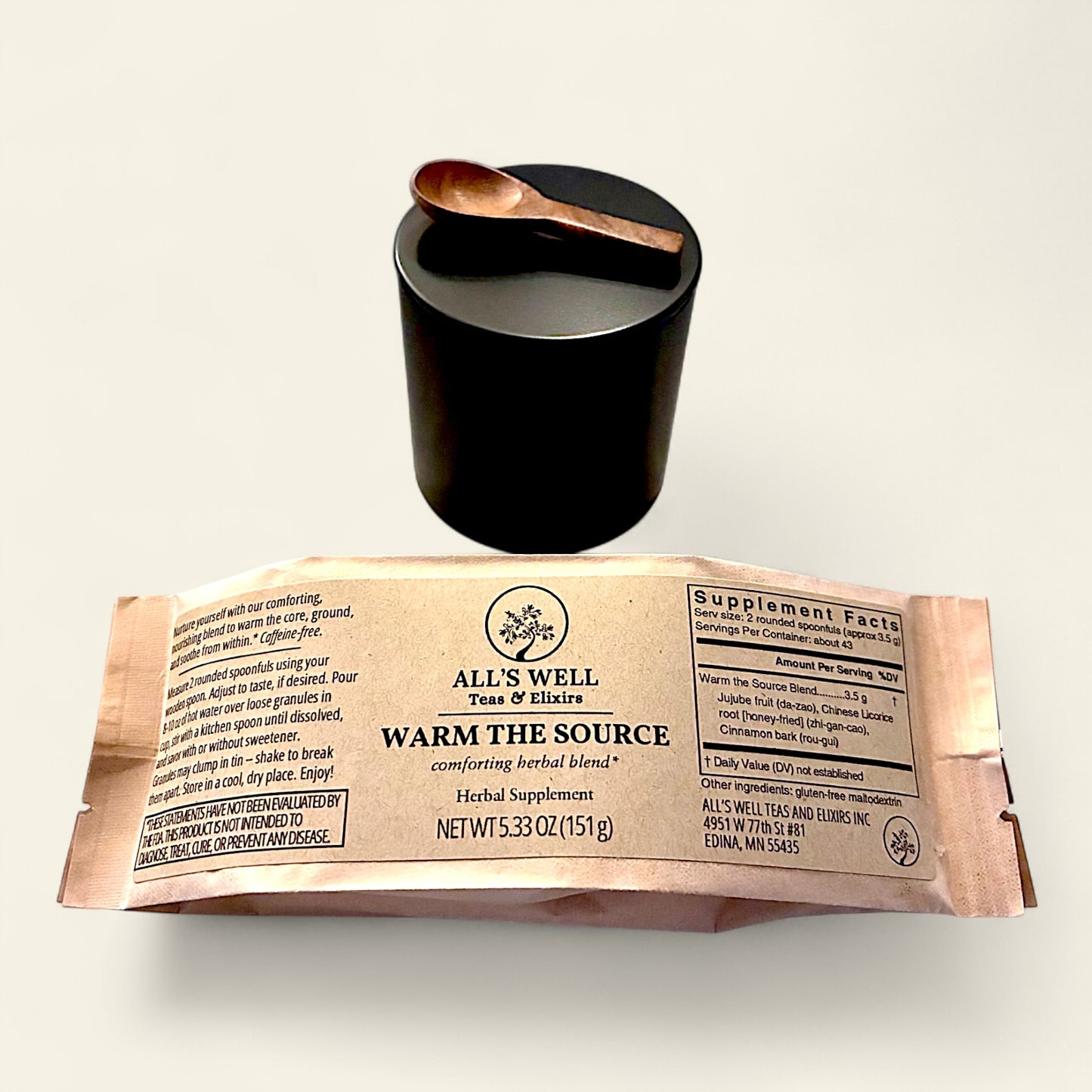 All's Well Teas and Elixirs Warm the Source - Our comforting, nourishing blend to warm the core, ground, and soothe from within.

Tea package with a black tin and wooden spoon on a light background